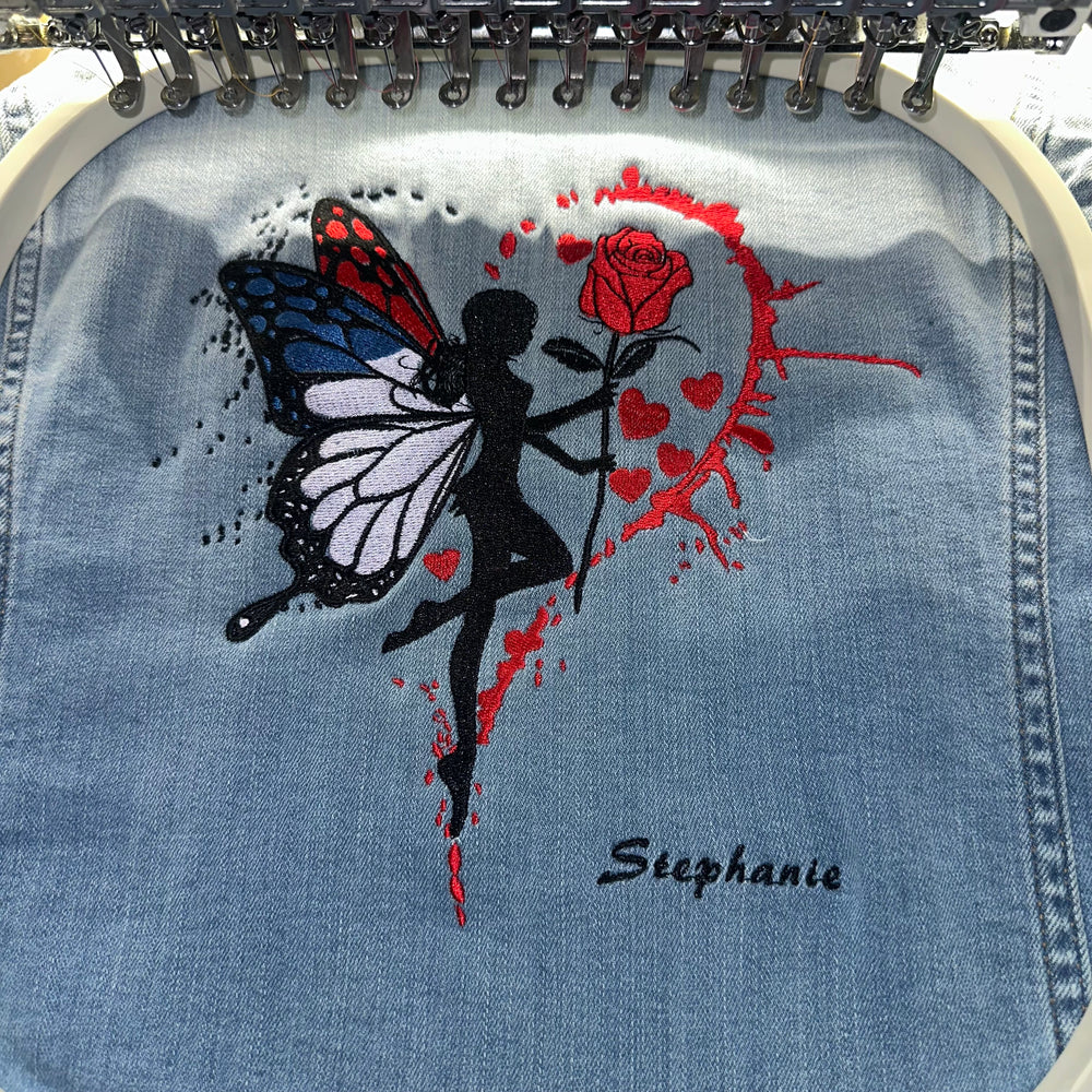 Butterfly and rose embroidery on denim in an embroidery hoop