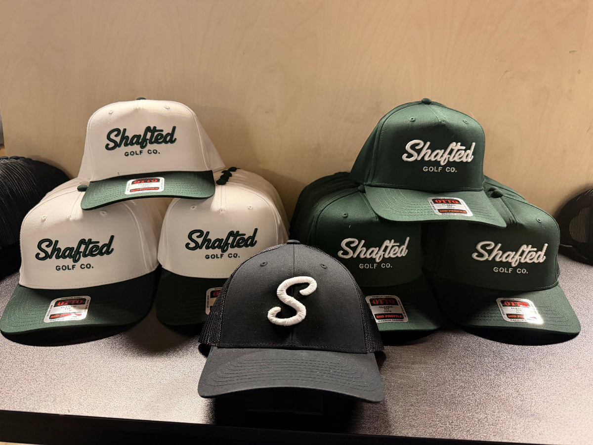 Custom embroidered Shafted Golf Co. hats in cream, forest green and black