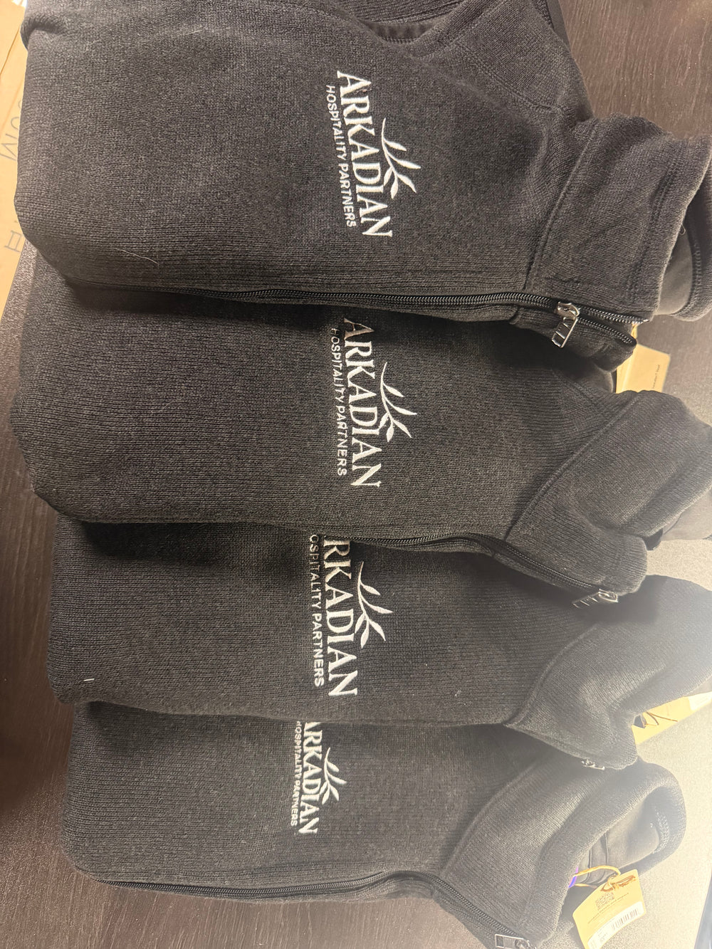 Stack of charcoal embroidered quarter-zips